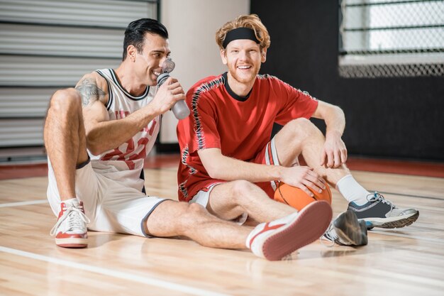 Depois do jogo. Dois jovens descansando após o jogo de basquete e conversando