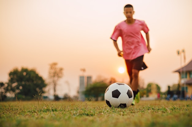 Foto deporte de acción al aire libre de niños jugando fútbol soccer.