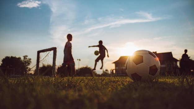 Deporte de acción de silueta al aire libre de niños divirtiéndose jugando al fútbol