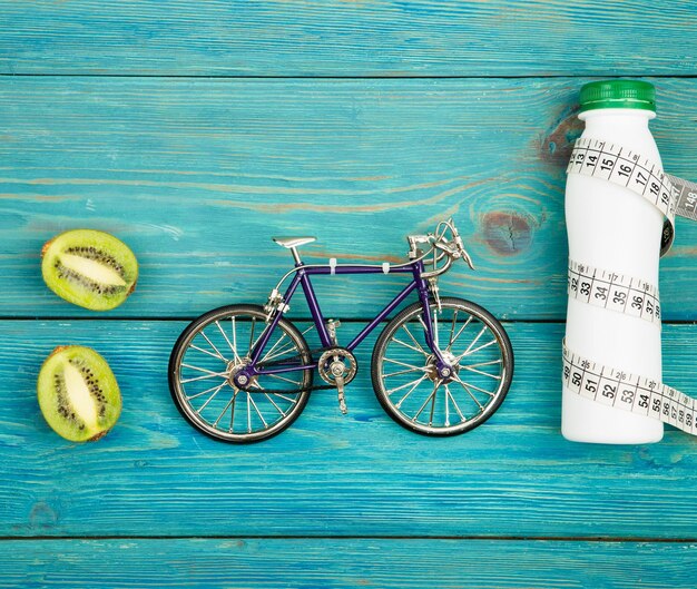 Deporte concepto bicicleta modelo botella de agua kiwi y cinta centimétrica