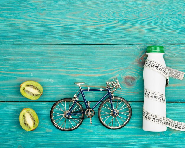 Deporte concepto bicicleta modelo botella de agua kiwi y cinta centimétrica