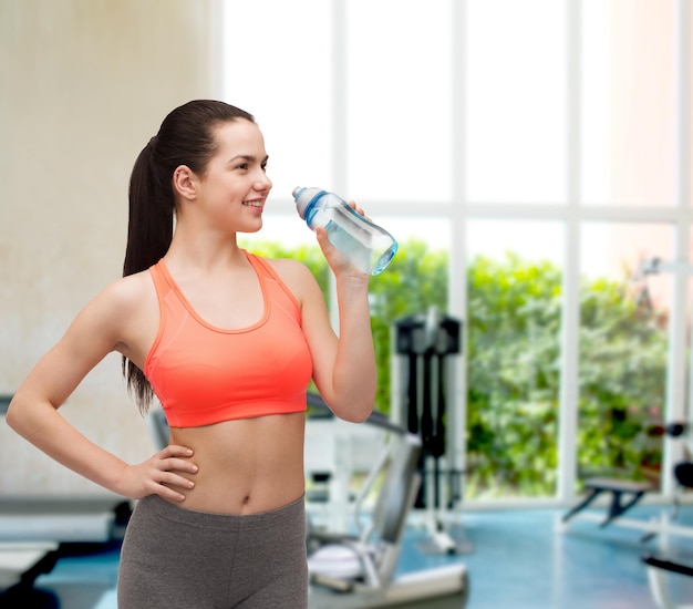 deporte, ejercicio y salud - mujer deportiva con botella de agua