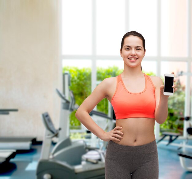 deporte, ejercicio, tecnología, internet y atención médica - mujer deportiva con pantalla de teléfono inteligente en blanco