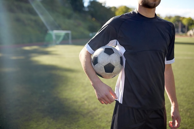 deporte, entrenamiento de fútbol y gente - cerca de jugador de fútbol con pelota en el campo