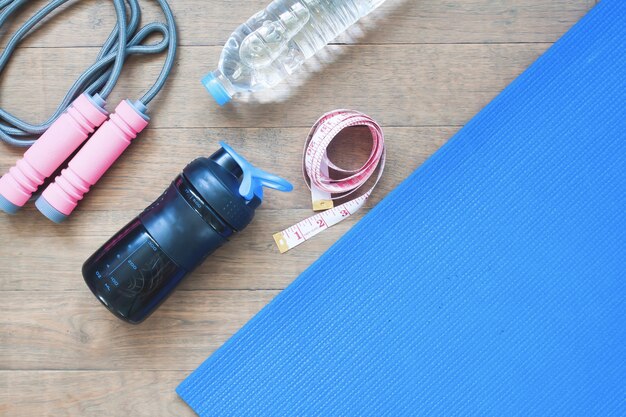 Foto deporte y equipos de yoga con cinta métrica sobre fondo de madera con espacio de copia