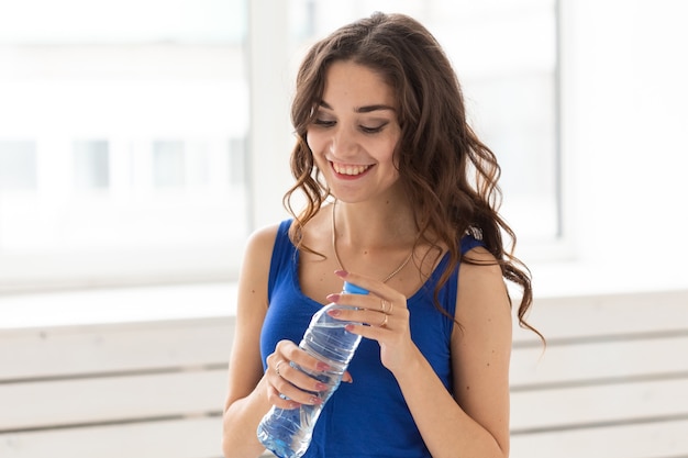 Deporte, estilo de vida saludable, concepto de personas. mujer joven bebiendo agua después del deporte.