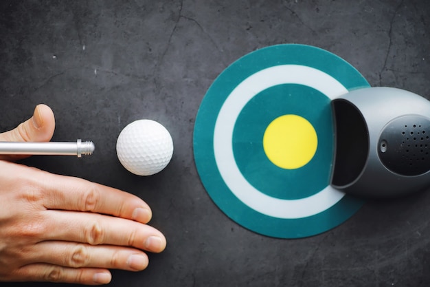 Foto deporte y estilo de vida saludable. mini golf. pelota de golf blanca y puesta para minigolf en la mesa. fondo deportivo con concepto de golf.