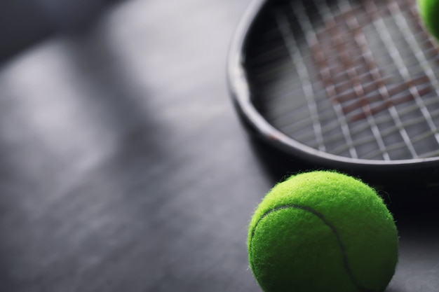 Deporte y estilo de vida saludable. Tenis. Pelota amarilla de tenis y raqueta sobre la mesa. Fondo deportivo con concepto de tenis.