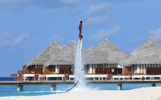 Deporte extremo acuático El hombre está volando en el flyboard acuático