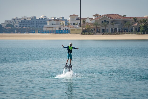 Deporte extremo acuático. El tipo está volando en el flyboard acuático. Descanso extremo en el mar.