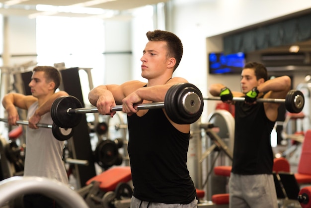deporte, fitness, estilo de vida y concepto de personas - grupo de hombres con pesas en el gimnasio