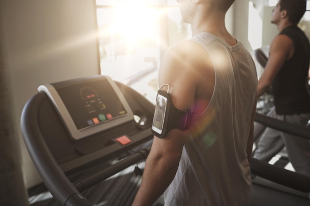 deporte, fitness, estilo de vida, tecnología y concepto de personas - hombres sonrientes haciendo ejercicio en la cinta de correr en el gimnasio