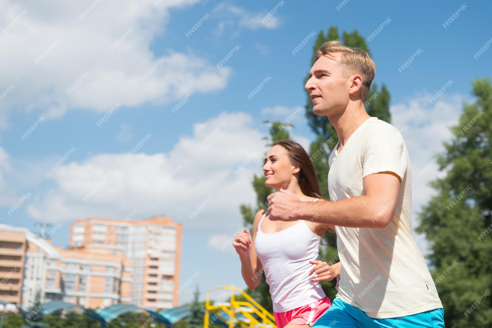 Deporte y fitness saludable. pareja corriendo en la pista de arena. entrenador y formador en el entrenamiento. hombre y mujer al aire libre soleado en el cielo azul. corredor de la competencia Deporte y fitness saludable. pareja corriendo en la pista de arena. entrenador y formador en el entrenamiento. hombre y mujer al aire libre soleado en el cielo azul. corredor de la competencia
