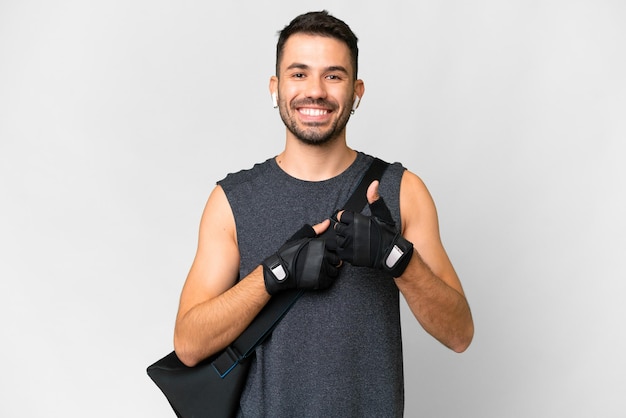 Deporte joven hombre caucásico con bolsa de deporte sobre fondo blanco aislado dando un gesto de pulgar hacia arriba