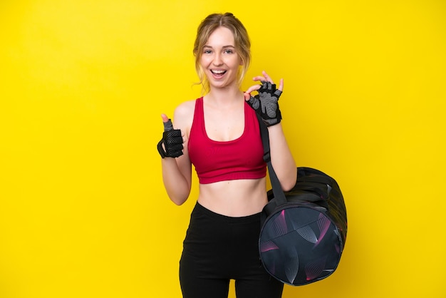Deporte joven mujer caucásica con bolsa de deporte fondo aislado mostrando signo ok y gesto de pulgar hacia arriba