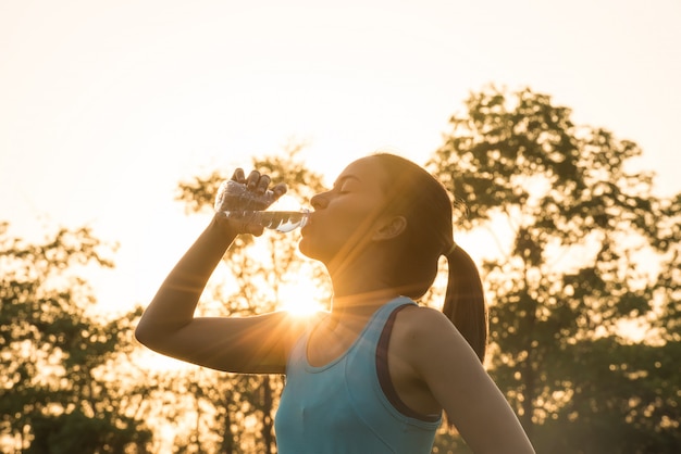 Foto deporte mujer agua potable durante la mañana para correr