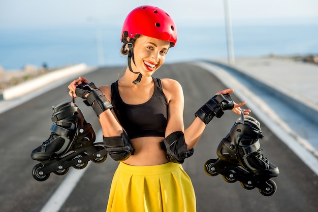 Deporte mujer en casco rojo con rodillos negros