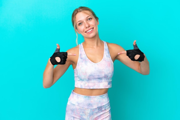 Deporte mujer caucásica aislada sobre fondo azul orgullosa y satisfecha