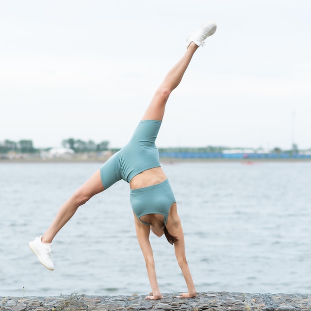 Deporte Una mujer hace las divisiones en el aire Ejercicios de estiramiento al aire libre Una mujer flexible Gimnasia flexibilidad cuerpo fitness