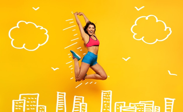 Deporte mujer salta sobre una superficie amarilla expresión feliz y alegre