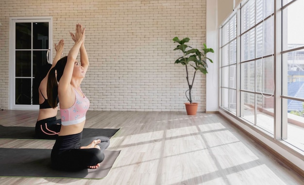 Foto deporte mujer sana en traje de yoga sentado haciendo meditación en el gimnasio
