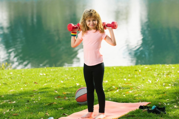 Deporte niño con fuertes músculos bíceps niños ejercicio fitness mancuernas fuerte ejercicio de niño pequeño