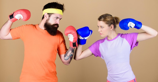 Deporte de perforación Entrenamiento de éxito con nocaut de entrenador y entrenamiento de pareja de energía en guantes de boxeo ropa deportiva Pelea Mujer feliz y hombre barbudo entrenan en gimnasio boxeo pareja entrenamiento de boxeo