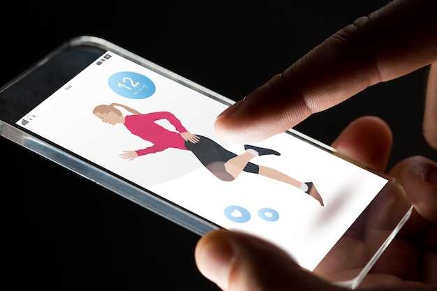deporte, personas y concepto de tecnología futura - cierre de manos con aplicación de fitness smartphone transparente sobre fondo negro