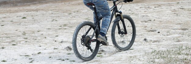 Deportes brutal chico barbudo en una bicicleta de montaña moderna Un ciclista en un lugar desierto de sal junto al lago