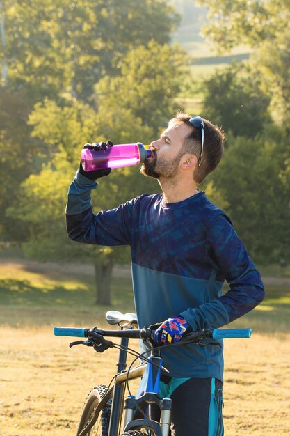 Deportes brutal chico barbudo en una bicicleta de montaña moderna Un ciclista en un lugar desierto de sal junto al lago