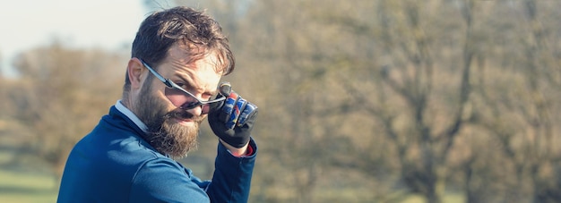 Deportes brutal chico barbudo en una bicicleta de montaña moderna Ciclista en las verdes colinas en la primavera