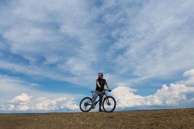 Deportes brutal hombre barbudo en una bicicleta de montaña moderna Un ciclista en un lugar desierto de sal junto al lago