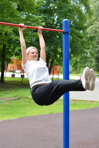 deportes callejeros en el patio de recreo en el parque mujer gimnasia