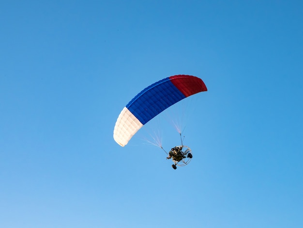 Deportes extremos. Paracaídas accionado contra el cielo azul.