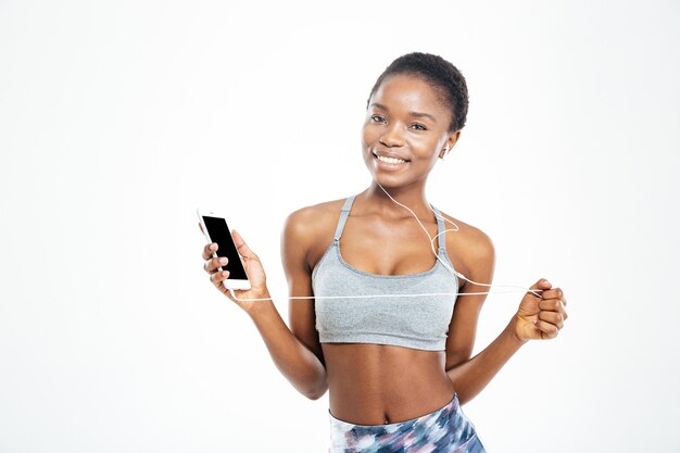 Deportista afroamericana joven linda sorprendida escuchando música en el teléfono móvil