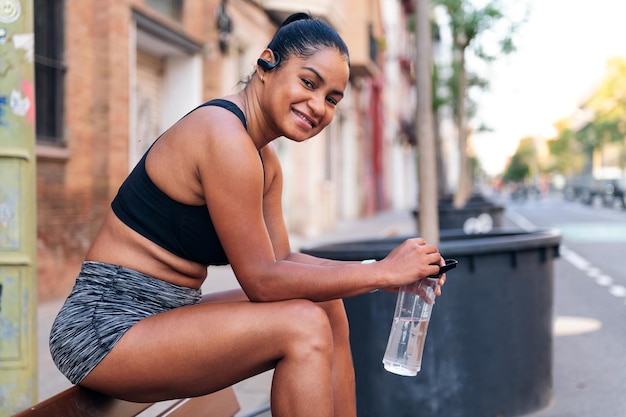 Deportista con un agua sonríe mirando a la cámara