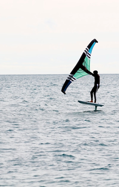 Foto deportista con ala navegando en el mar