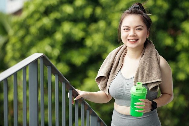 Deportista alegre con batido de proteínas