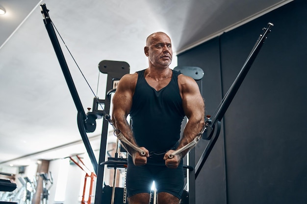 Deportista anciano calvo en el gimnasio durante el entrenamiento que es un entrenador o instructor de atletas