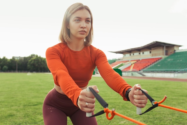 deportista atlética haciendo ejercicio con correas TRX durante un intenso entrenamiento de suspensión