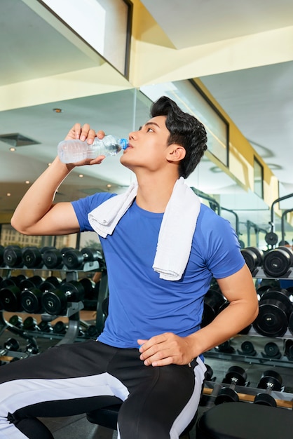 Deportista bebiendo agua después del entrenamiento