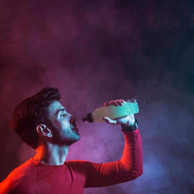 Foto deportista con botella de bebida