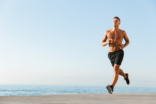 Foto deportista sin camisa feliz corriendo