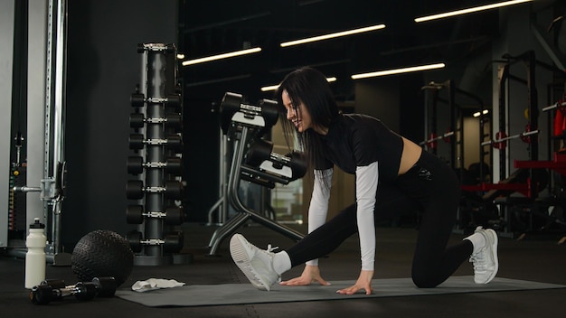 Deportista caucásica instructora de fitness entrenadora mujer atlética realiza ejercicios de estiramiento