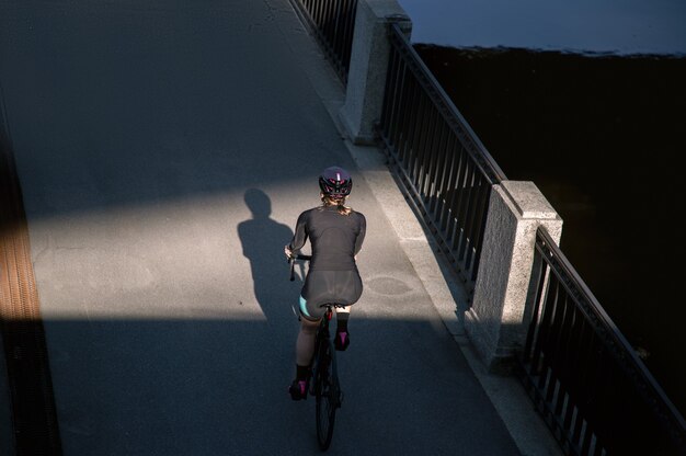 Deportista de ciclismo iluminada por el sol poniente