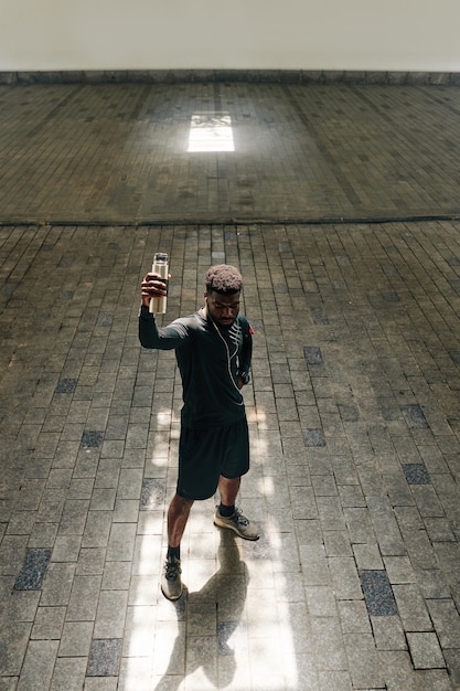 Deportista confiado con botella de agua