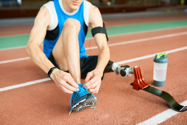 Deportista discapacitado atar cordones de zapatos