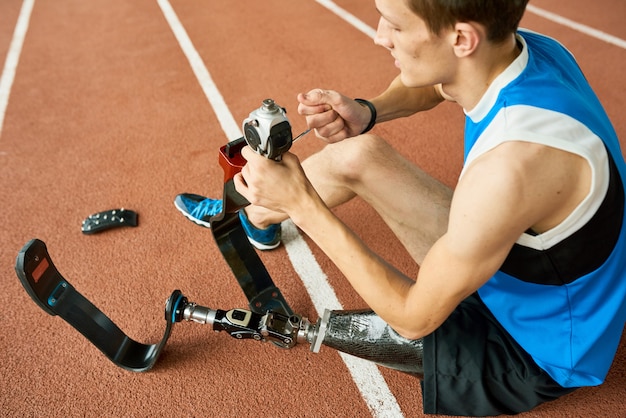 Deportista discapacitado que repara la pierna protésica