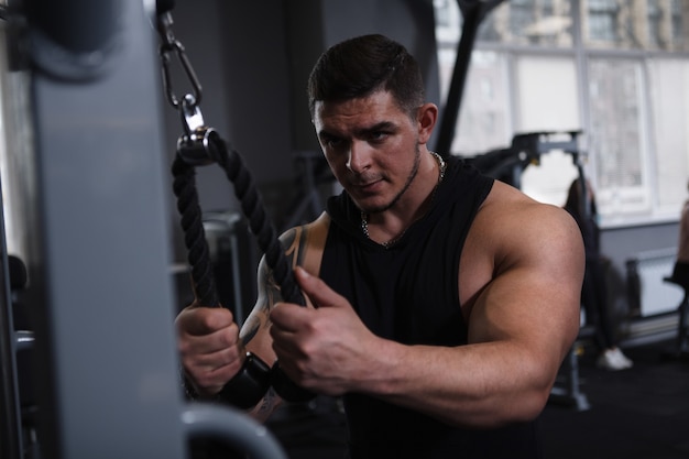 Deportista guapo mirando concentrado, haciendo ejercicio en el gimnasio