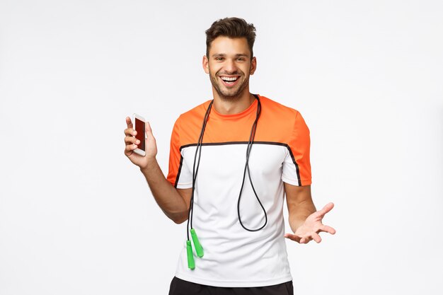 Foto deportista guapo y sexy utiliza la aplicación de deporte de fitness en el teléfono inteligente para seguir su puntaje